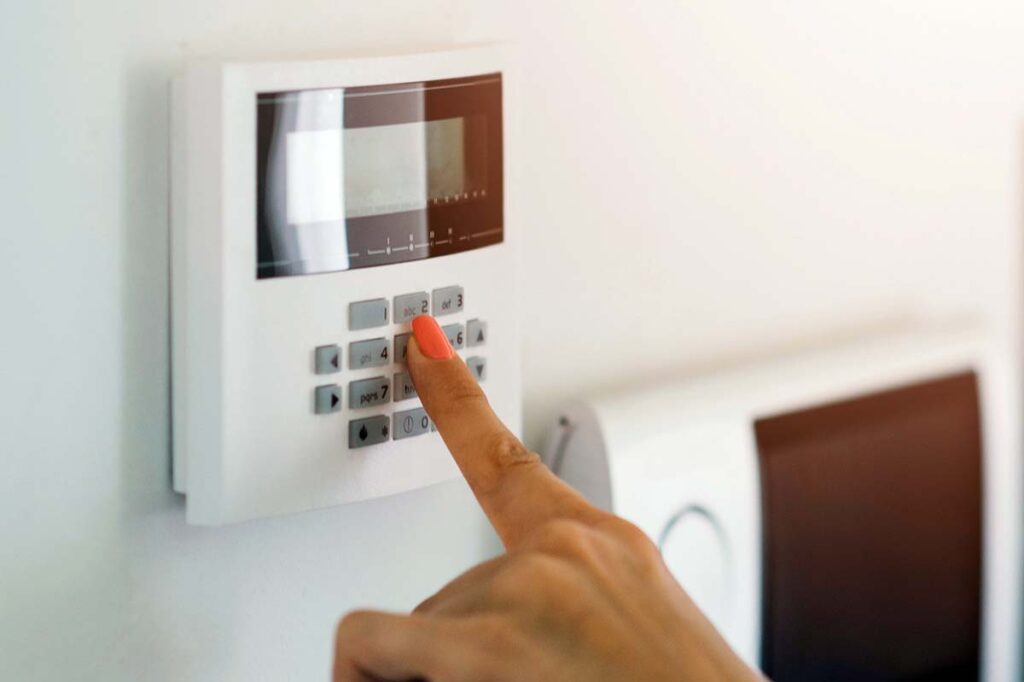 Homeowner testing a modern home alarm panel